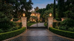 Beverly Hills luxury real estate estate entrance gate and manicured driveway at dusk